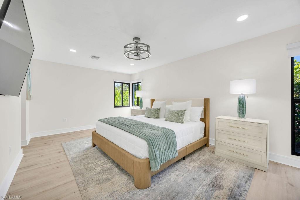 3155 64th Street Southwest Naples, FL 34105 - Photo 15 of 45 a spacious bedroom with a bed and a lamp