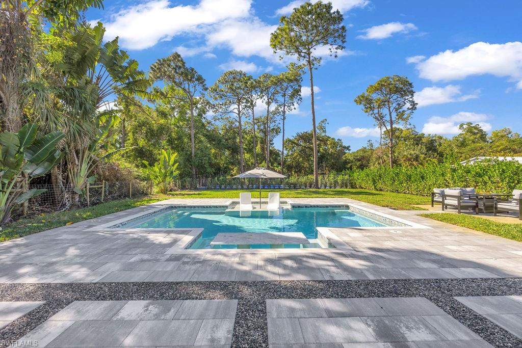 3155 64th Street Southwest Naples, FL 34105 - Photo 31 of 45 a view of a swimming pool with an outdoor space and seating area