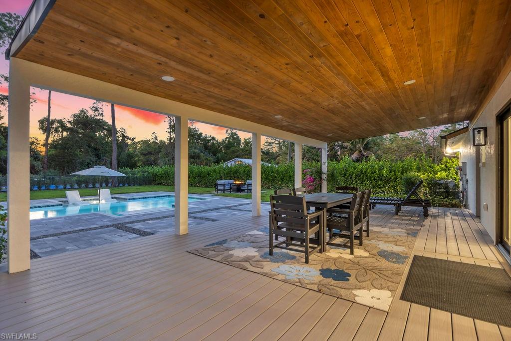 3155 64th Street Southwest Naples, FL 34105 - Photo 39 of 45 a view of a patio with table and chairs potted plants with wooden floor and floor to ceiling window