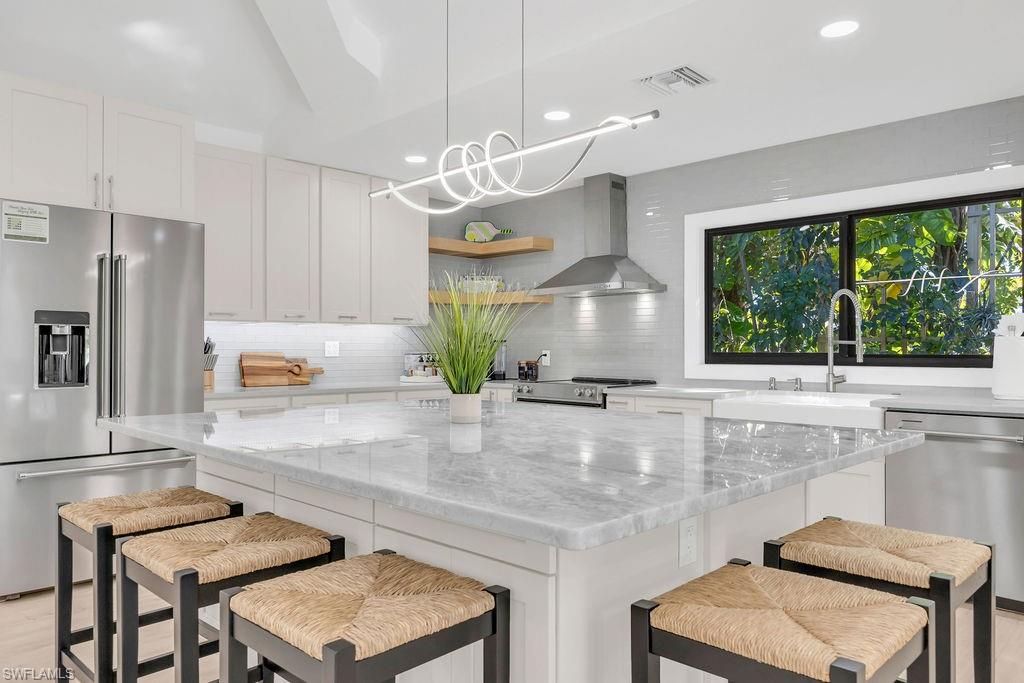 3155 64th Street Southwest Naples, FL 34105 - Photo 9 of 45 a kitchen with stainless steel appliances granite countertop a stove and a refrigerator