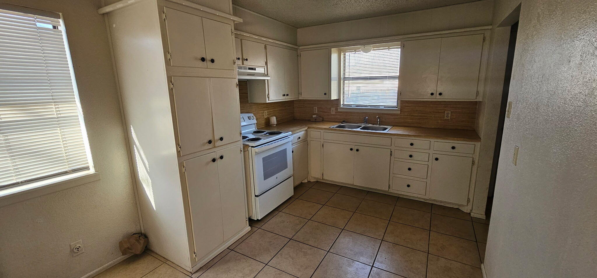 2318 33rd Street Lubbock, TX 79411 - Photo 4 of 8 a kitchen with a stove sink and cabinets