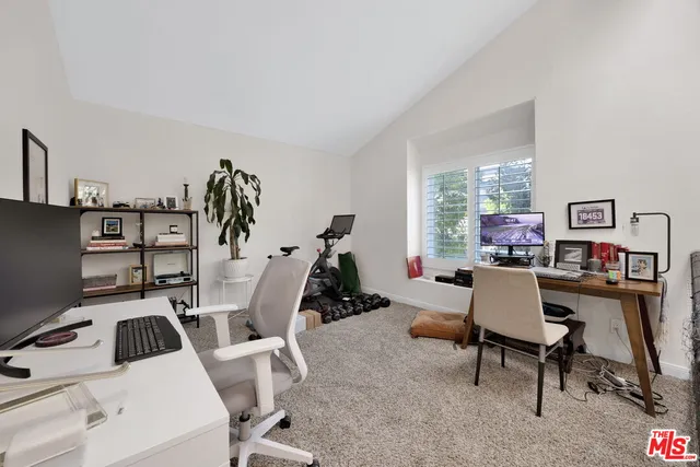 a view of a workspace with furniture and a window