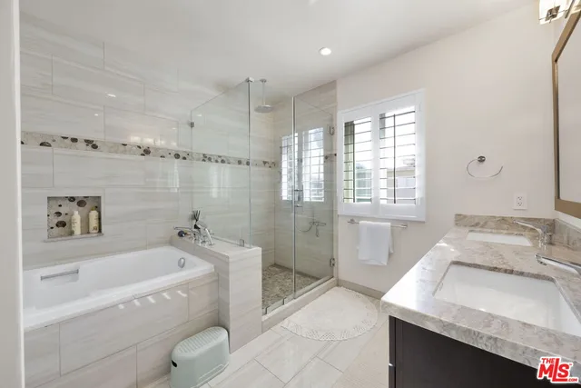 a spacious bathroom with a tub sink and mirror