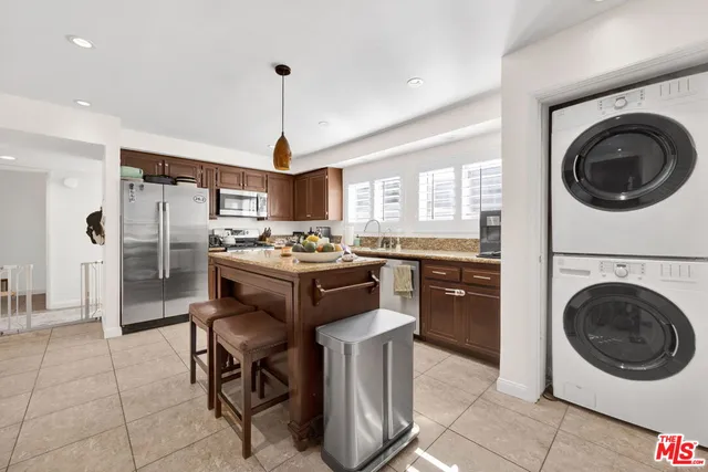 a kitchen with kitchen island a stove a refrigerator and a stove top oven