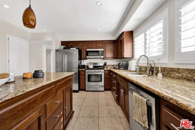 a modern kitchen with granite countertop stainless steel appliances a stove sink and cabinets