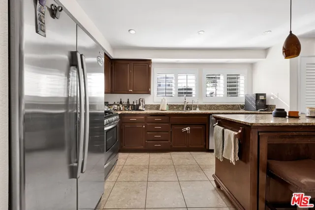 a kitchen with a refrigerator sink and cabinets