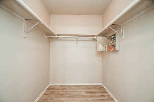 a bathroom with a granite countertop sink a mirror and wooden floor