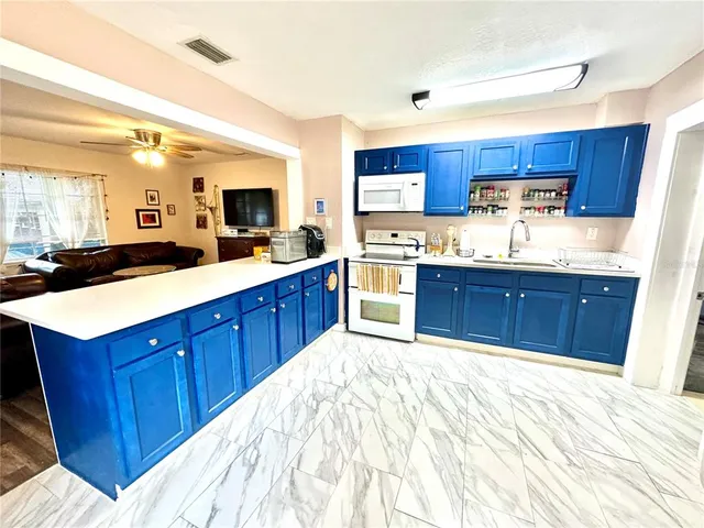 a kitchen with stainless steel appliances granite countertop a sink stove and cabinets