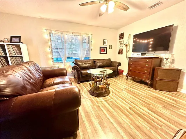 a living room with furniture a large window with wooden floor