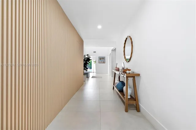 a view of a white house with a small yard and plants