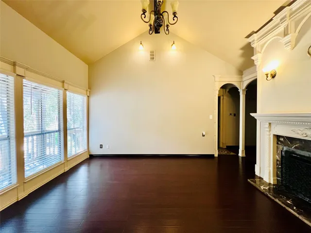a view of empty room with wooden floor and fireplace