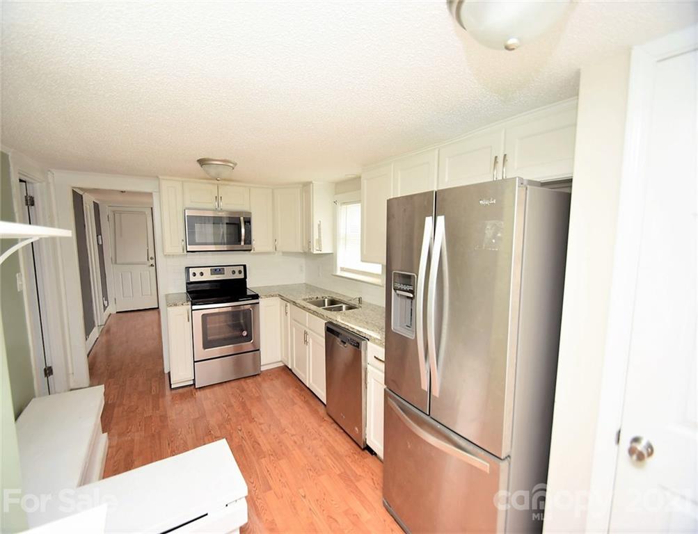 4707 Boyd Griffin Road Monroe, NC 28110 - Photo 7 of 12 a kitchen with stainless steel appliances a refrigerator sink and microwave