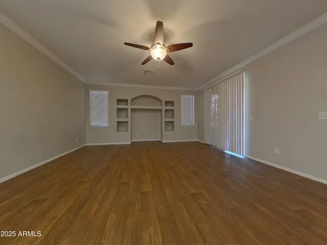 a view of a electric appliances in kitchen and empty room with wooden floor