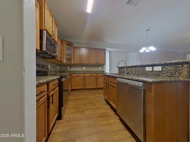 a kitchen with stainless steel appliances granite countertop a stove and a microwave