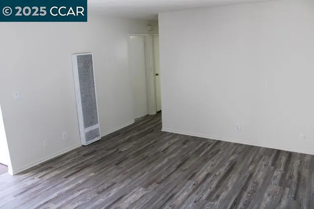 a view of an empty room with wooden floor