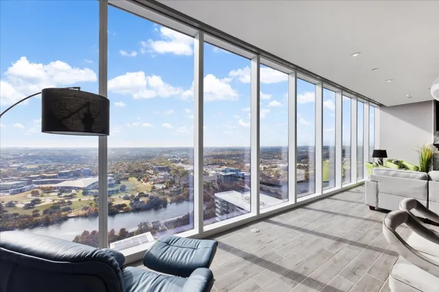a living room with furniture and floor to ceiling windows