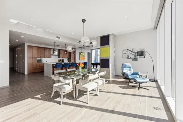a view of a dining room and livingroom with furniture wooden floor a chandelier