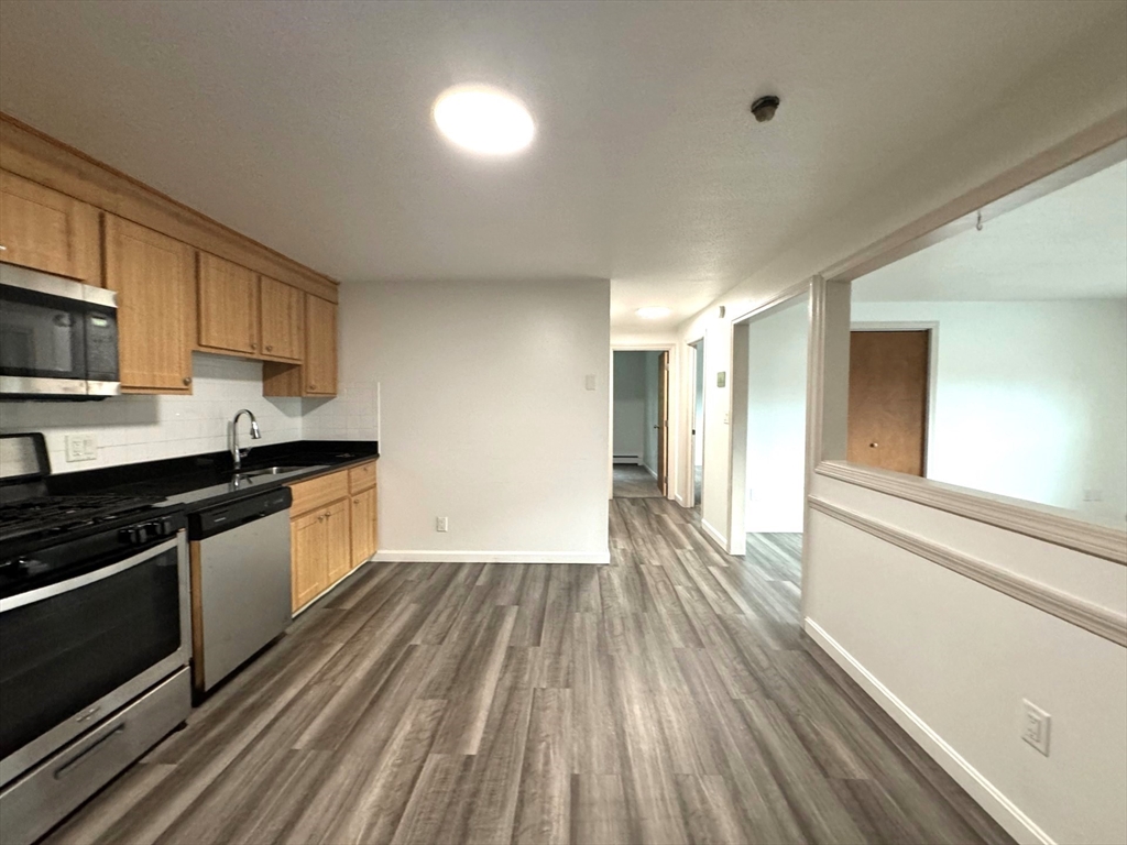 a kitchen with a sink and wooden floor