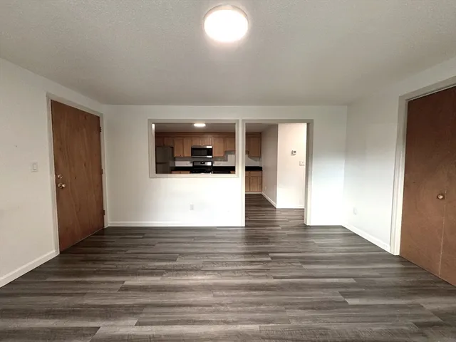 a view of a kitchen with wooden floor and a ceiling fan