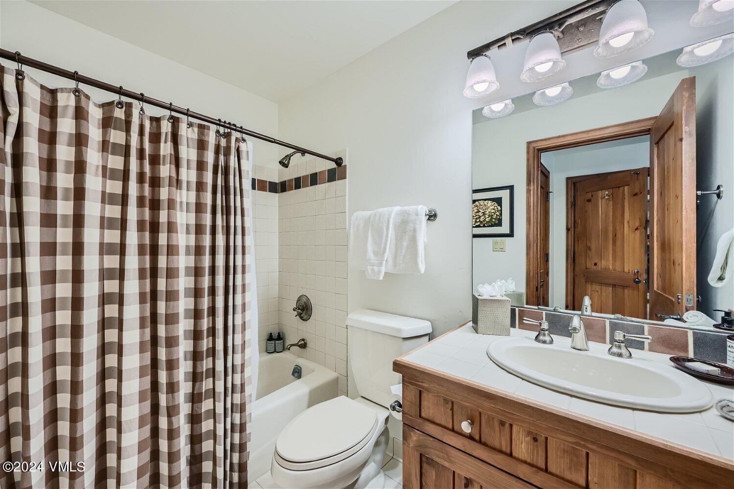 51 Offerson Road, Unit 202 Beaver Creek, CO 81620 - Photo 12 of 19 a bathroom with a sink a toilet a mirror and shower