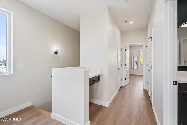 a view of a hallway with wooden floor and a living room