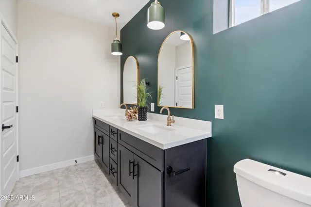 a bathroom with a double vanity sink toilet and a mirror