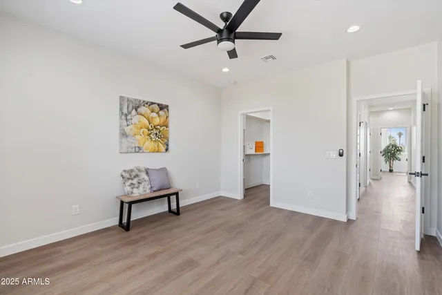 a view of a livingroom with wooden floor and a ceiling fan
