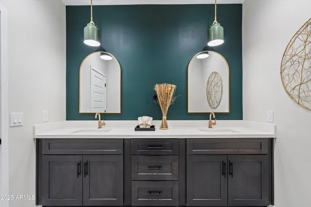 a bathroom with double vanity sinks and a mirror