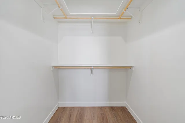 a view of walk in closet with wooden floor
