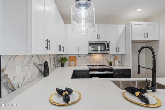 a kitchen with white cabinets and appliances