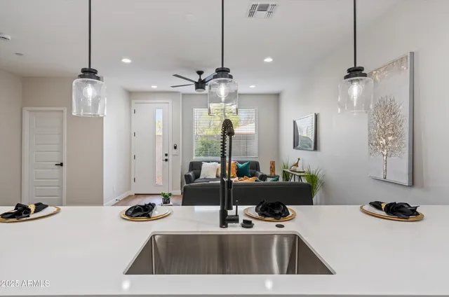 a kitchen that has a sink and a stove with the view of living room