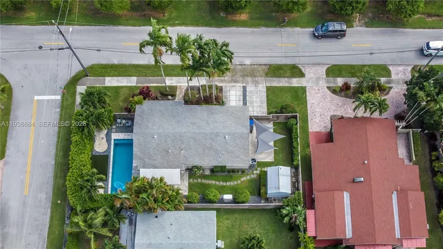 an aerial view of residential houses with outdoor space and trees