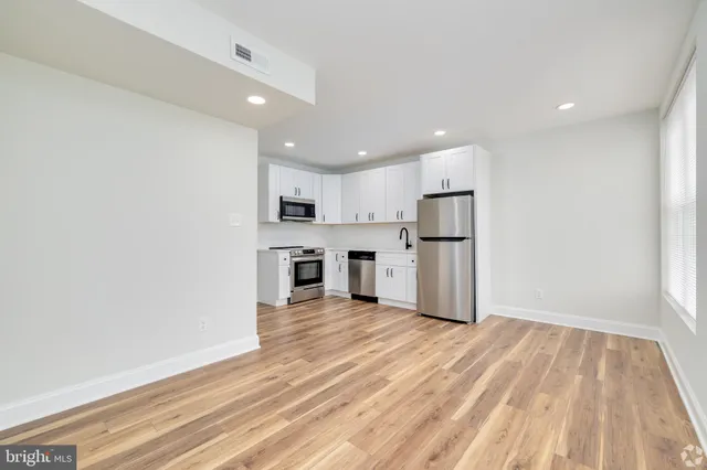 a view of a kitchen with a sink and dishwasher a refrigerator with wooden floor
