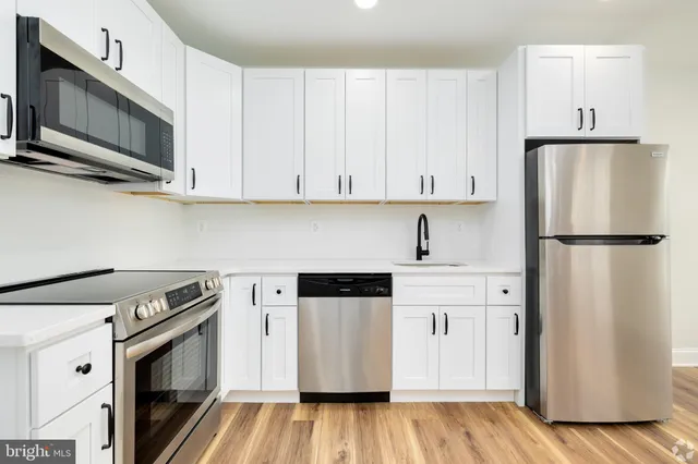 a kitchen with stainless steel appliances a refrigerator stove and microwave