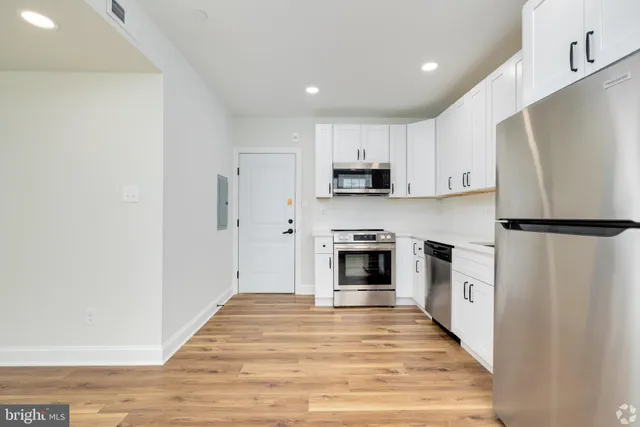 a kitchen with white cabinets and stainless steel appliances