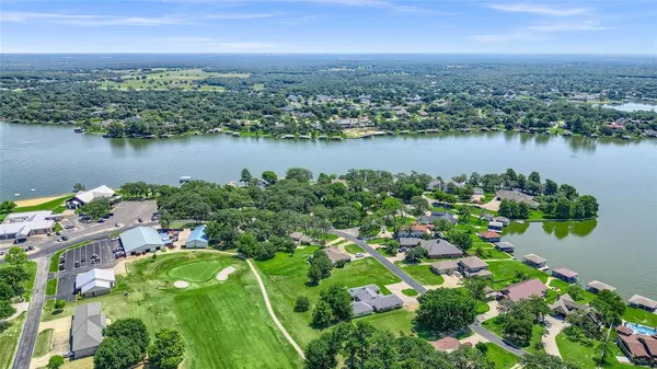 an aerial view of lake residential house with outdoor space and trees around