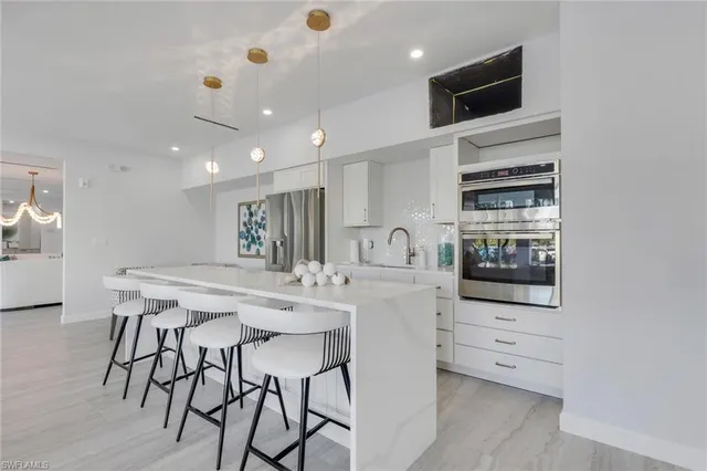 a kitchen with a sink a center island a counter space and a window
