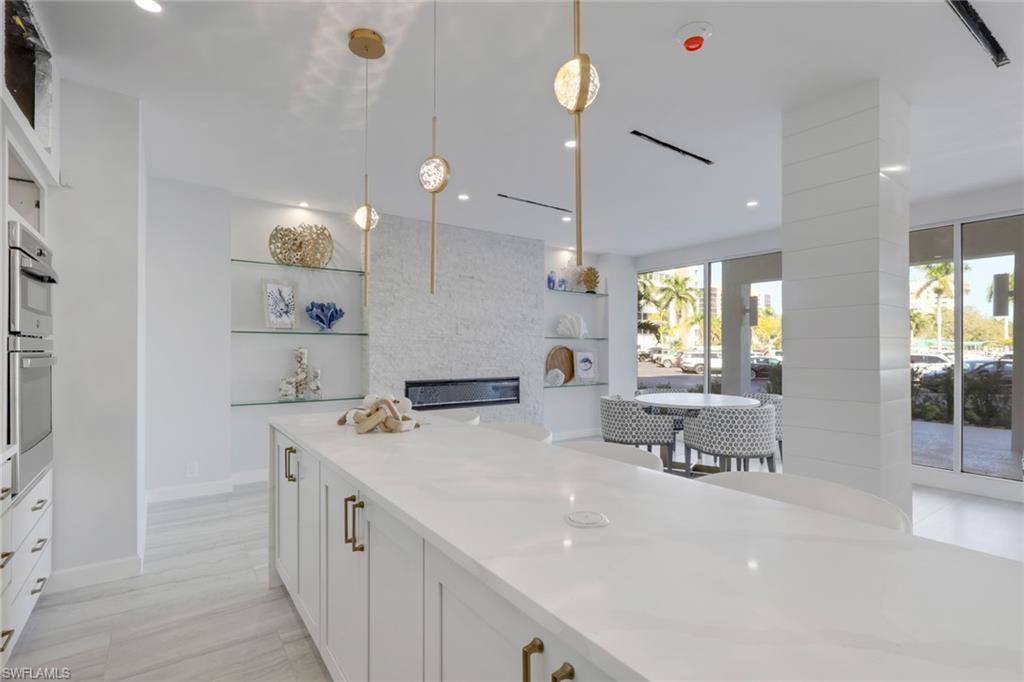 1 Bluebill Avenue, Unit 703 Naples, FL 34108 - Photo 28 of 31 a kitchen with a sink a center island a counter space and a window