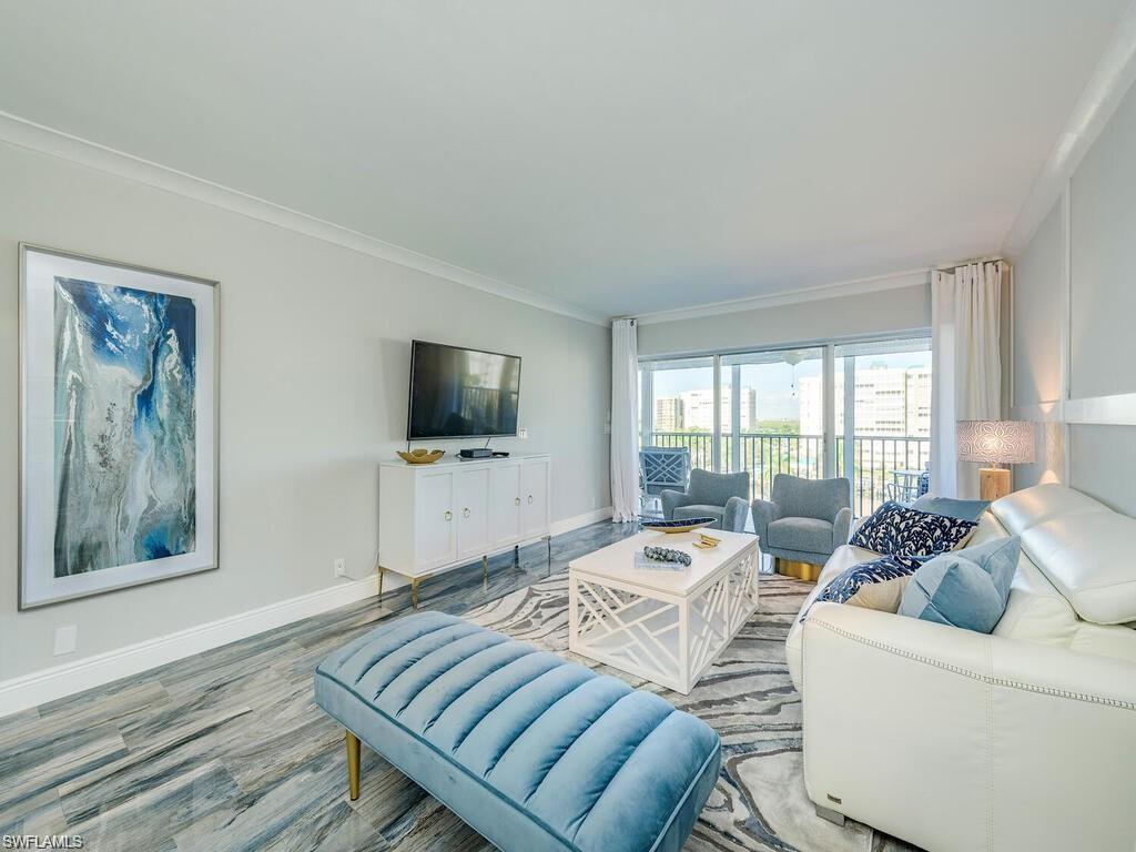1 Bluebill Avenue, Unit 703 Naples, FL 34108 - Photo 5 of 31 a living room with furniture and a flat screen tv