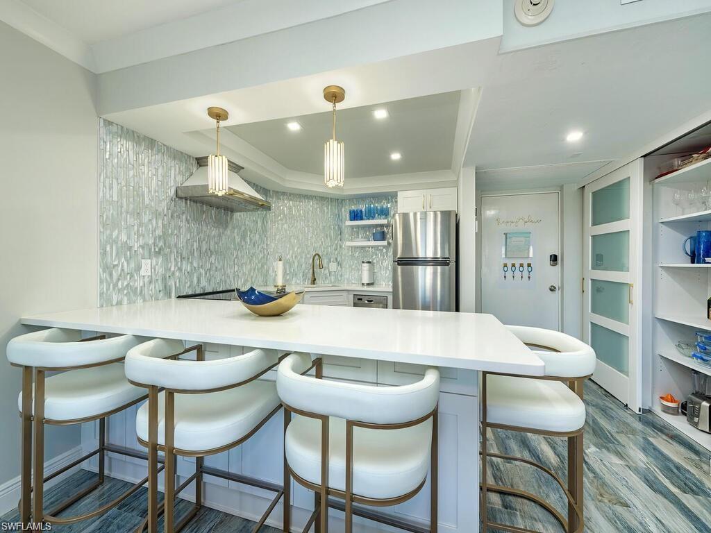 1 Bluebill Avenue, Unit 703 Naples, FL 34108 - Photo 6 of 31 a kitchen with a table and chairs in it