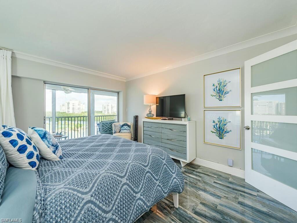 1 Bluebill Avenue, Unit 703 Naples, FL 34108 - Photo 8 of 31 a bedroom with a bed and a flat screen tv