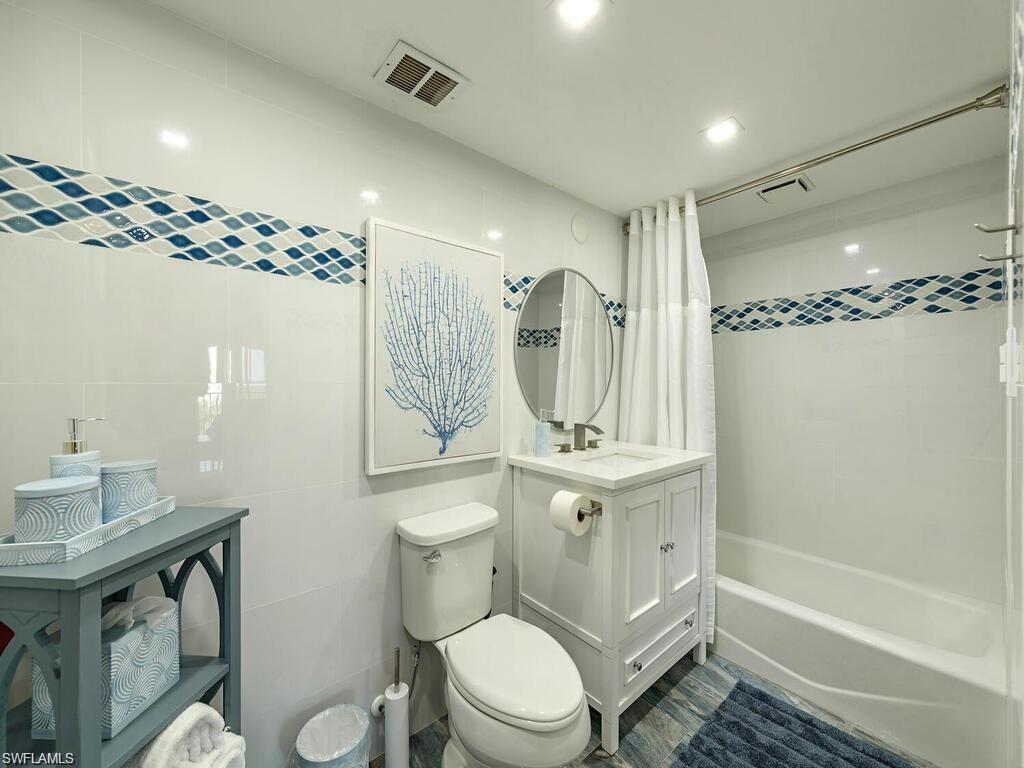 1 Bluebill Avenue, Unit 703 Naples, FL 34108 - Photo 9 of 31 a bathroom with a sink toilet a mirror and shower