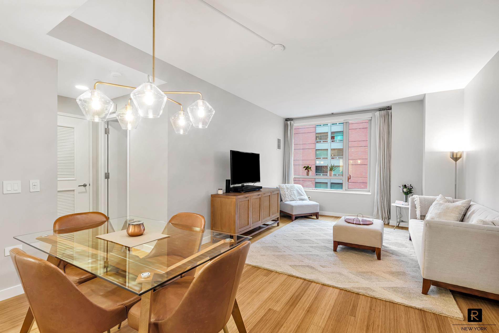 a living room with furniture a chandelier and a flat screen tv