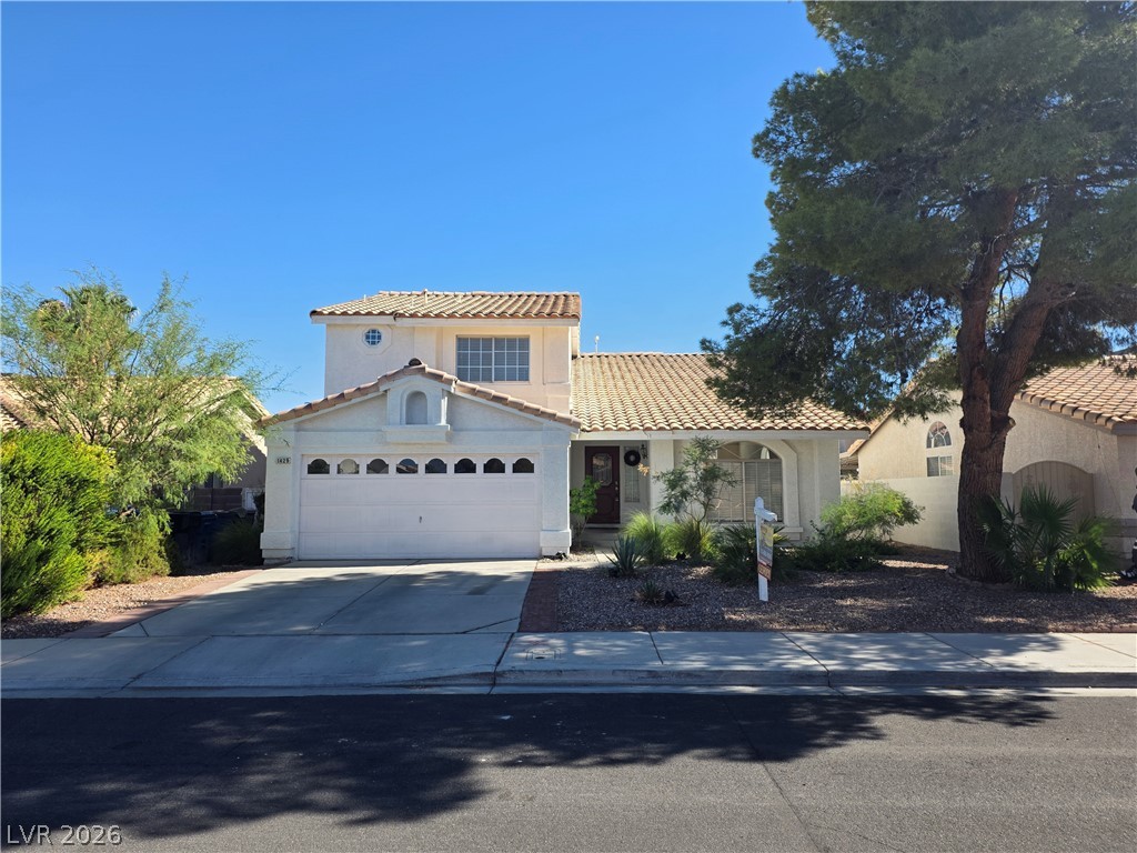 1429 Hawkwood Road Henderson, NV 89014 - Photo 42 of 53 Mediterranean-inspired architecture highlights this multi-level home featuring a tile roof and attached garage.