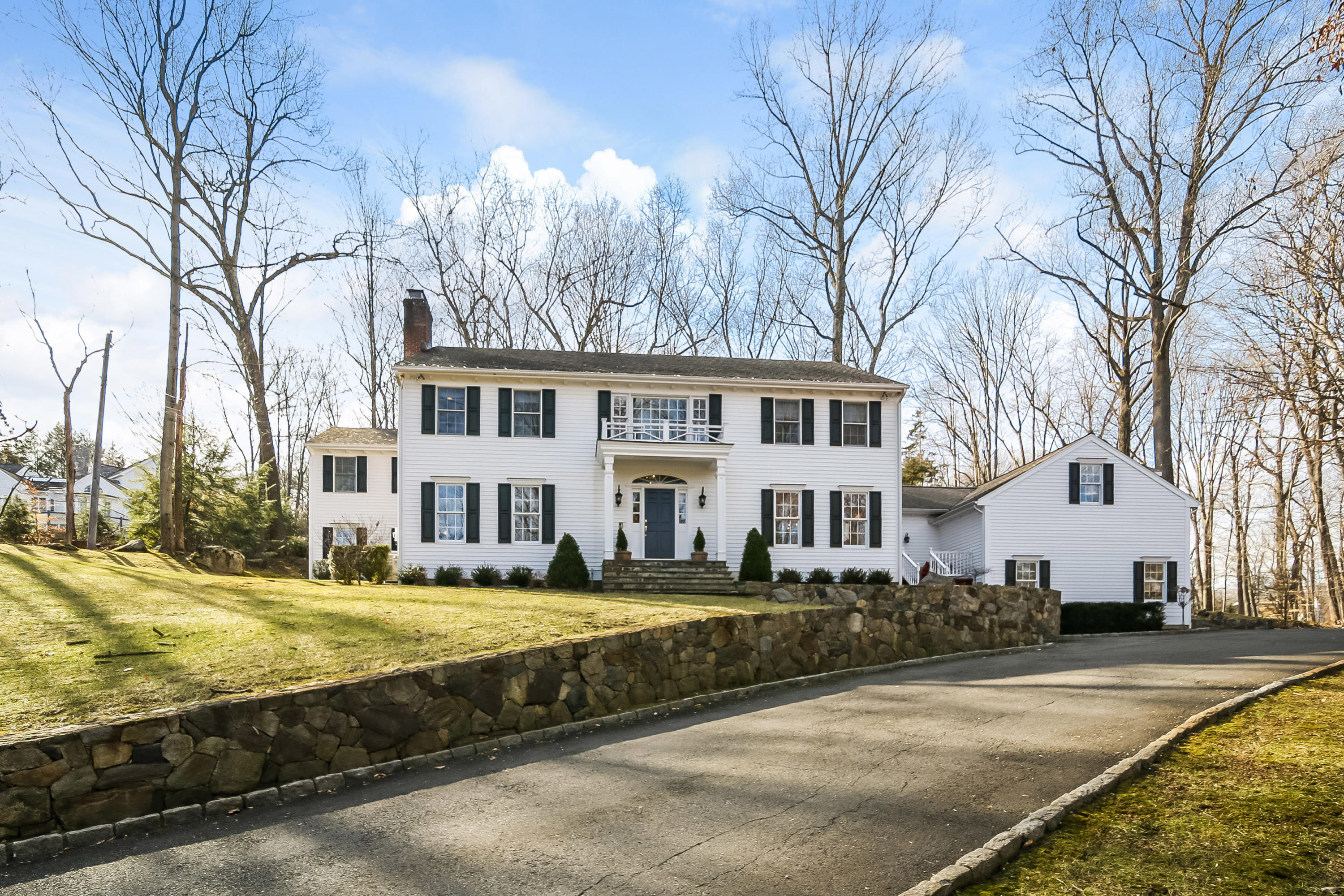 228 Laurel Road New Canaan, CT 06840 - Photo 1 of 38 a view of a house with a big yard and large trees