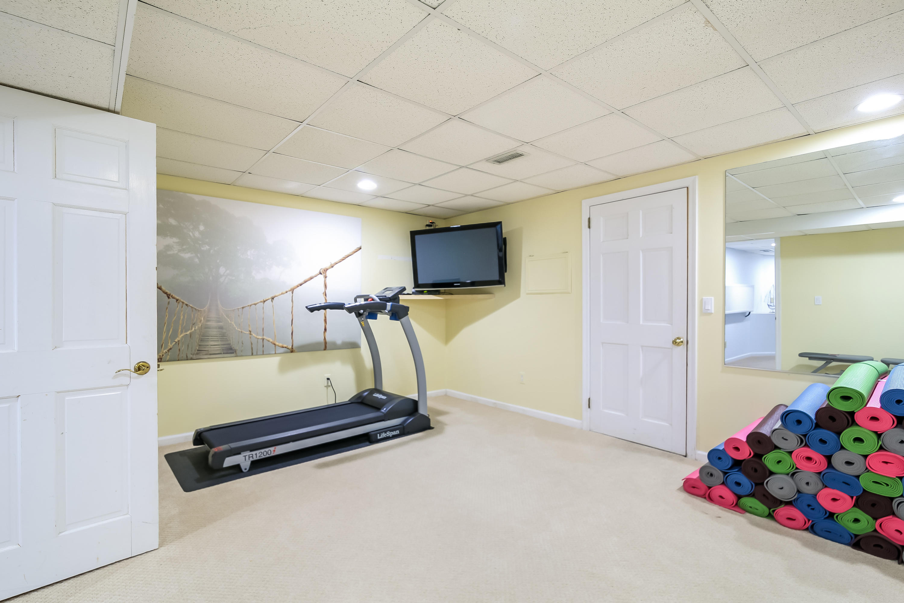 228 Laurel Road New Canaan, CT 06840 - Photo 31 of 38 a room with gym equipment and a flat screen tv
