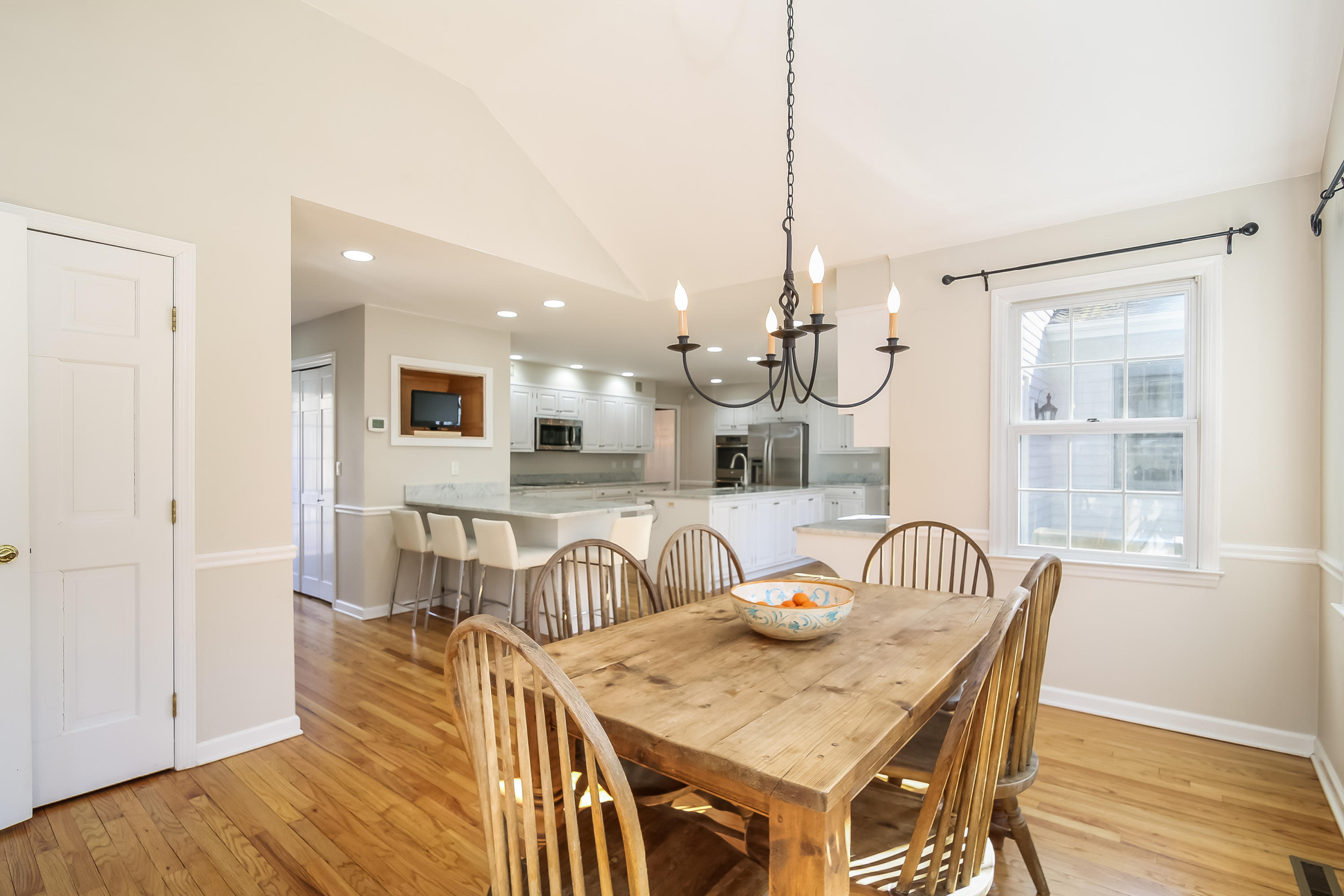 228 Laurel Road New Canaan, CT 06840 - Photo 7 of 38 a view of a dining room and livingroom with furniture wooden floor a chandelier
