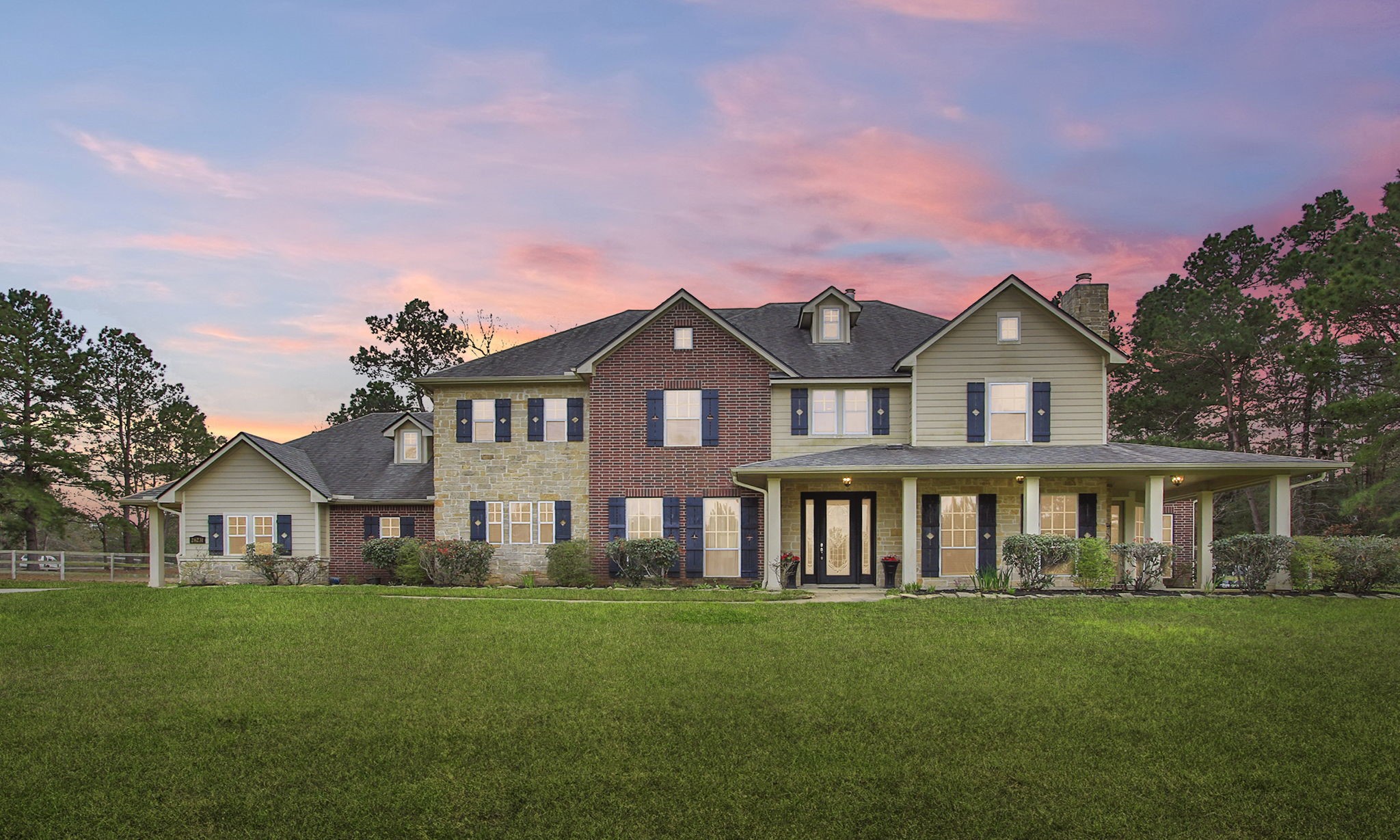 a view of a house with a big yard and large trees
