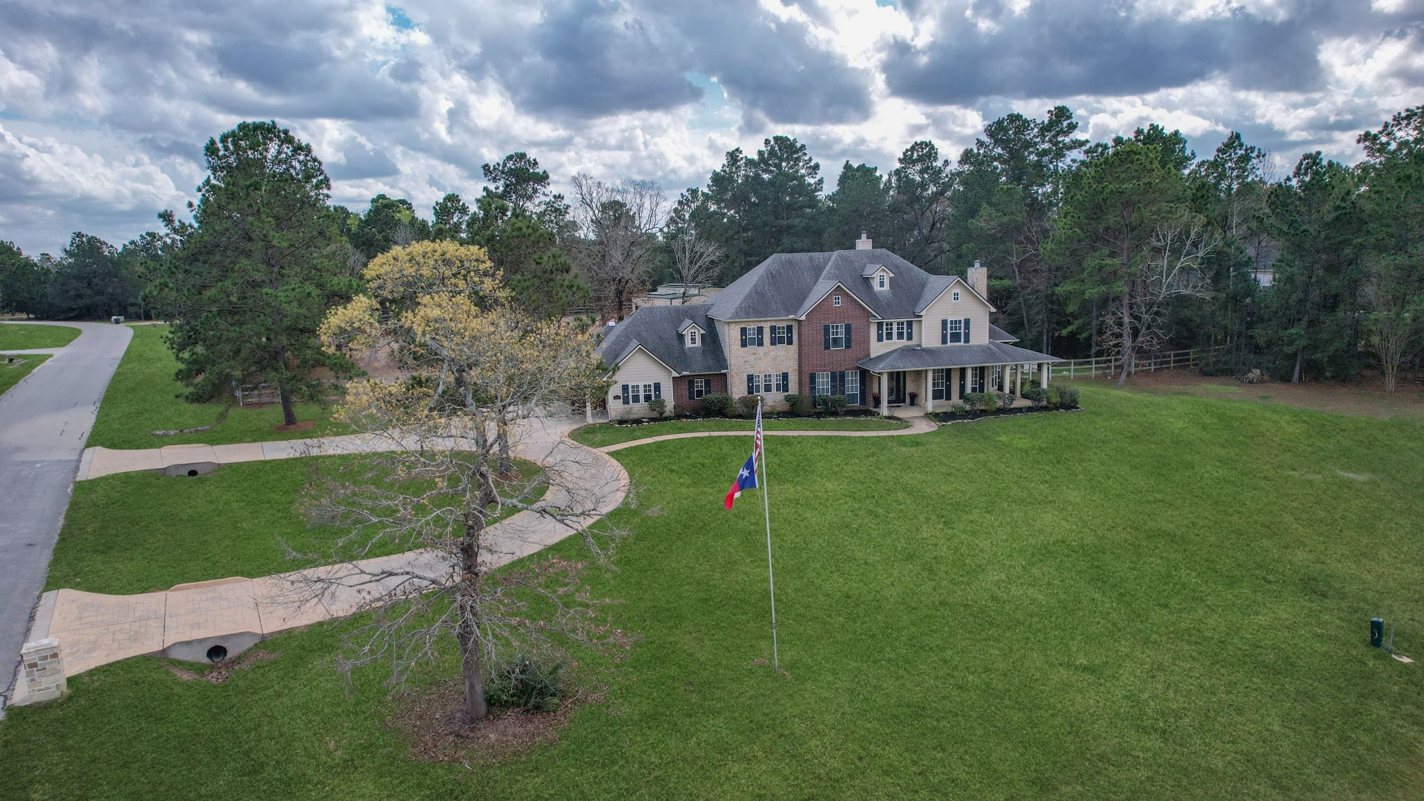 26231 Crown Ranch Boulevard Montgomery, TX 77316 - Photo 2 of 46 an aerial view of a house with swimming pool and garden