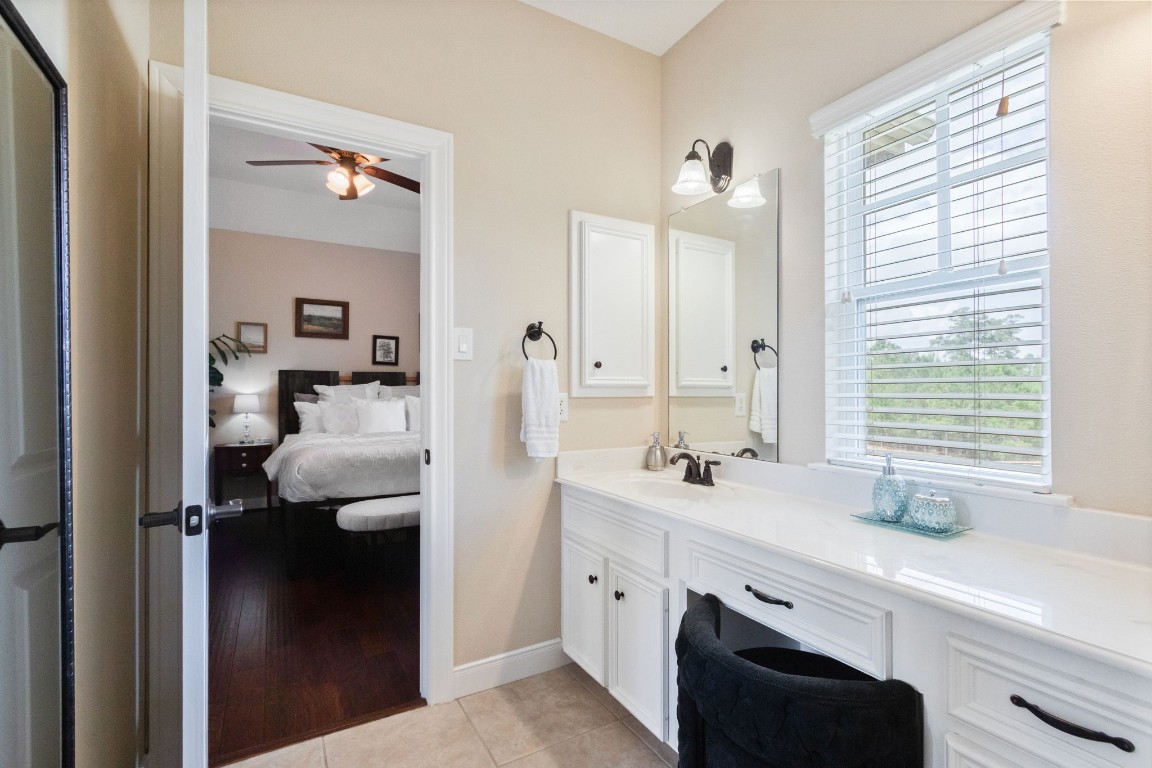 26231 Crown Ranch Boulevard Montgomery, TX 77316 - Photo 25 of 46 a en suite bathroom with a double vanity sink a mirror and a shower